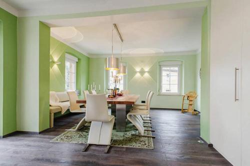 拜罗伊特Villa Johner的一间拥有绿色墙壁和桌椅的用餐室