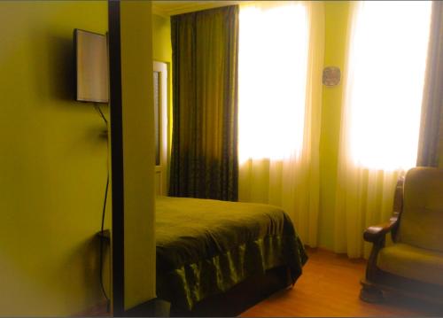 西格纳吉Lelis Guest House的一间卧室配有一张床、镜子和窗户