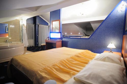 Špišić-Bukovica莫扎特酒店的一间卧室设有一张大床和蓝色的墙壁