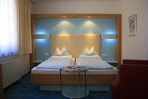 林茨冬穆酒店的酒店客房设有两张床和一张桌子。