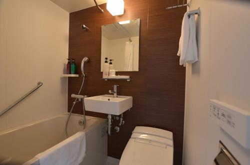 谏早市谏早市第一酒店的一间带水槽、卫生间和镜子的浴室