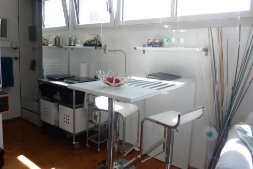 Ueberstorf优雅住宿加早餐旅馆的白色的厨房,配有柜台和凳子