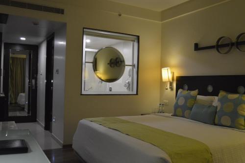 维沙卡帕特南Fortune Inn Sree Kanya, Visakhapatnam - Member ITC's Hotel Group的一间卧室配有一张大床和镜子