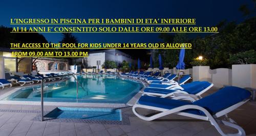 卡普里萨恩菲勒斯酒店的游泳池旁设有蓝色躺椅