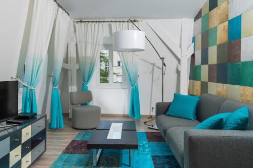 沙特尔Les Toits de Chartres - 2 appt - Parking gratuit的客厅配有沙发和桌子