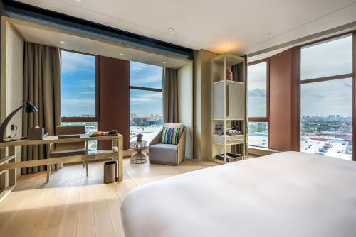 上海上海客莱福诺富特酒店 （原：上海康桥诺富特酒店）的卧室配有一张床、一张书桌和窗户。