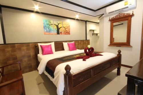素可泰TR宾馆的卧室配有一张带粉红色枕头的大床