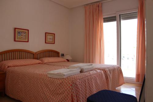拉曼加戴尔马尔梅纳多米尼克公寓酒店的一间卧室配有一张床,上面有两条毛巾