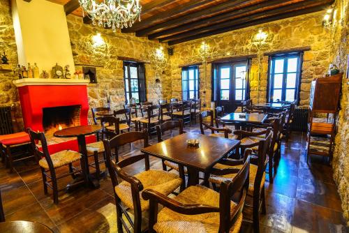 上特里卡拉瓦纳沃旅馆的一间带桌椅和壁炉的餐厅