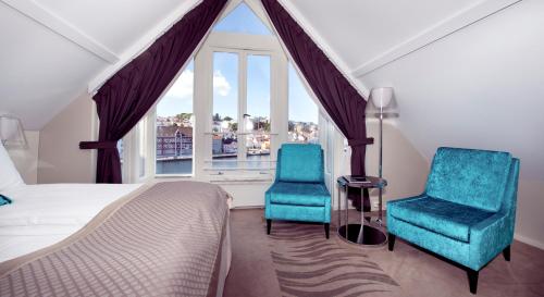 斯塔万格斯卡恩布莱格号角集品酒店的一间卧室配有两把椅子、一张床和窗户