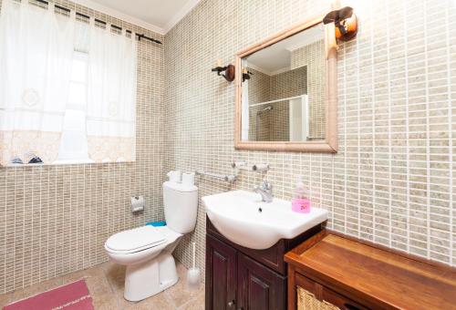 普赖尼亚德拜舒Adega Poça的一间带卫生间、水槽和镜子的浴室