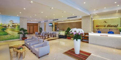 胡志明市雅集西贡酒店的大堂,设有桌椅和鲜花