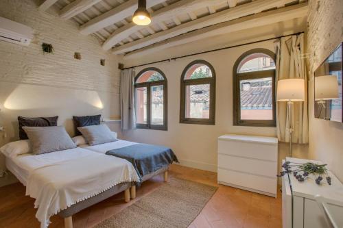 赫罗纳弗拉特里巴拉斯特里斯公寓的一间带两张床的卧室,位于带窗户的房间内