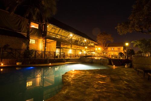 马翁马翁酒店的一座游泳池,在晚上在建筑物前