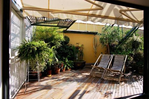 戛纳戛纳阁楼住宿加早餐旅馆的庭院里摆放着两把椅子,种满了植物