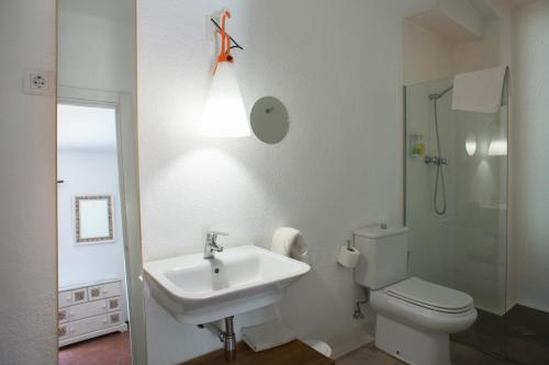罗萨斯凯拉琼科斯酒店的浴室配有水槽、卫生间和灯具。