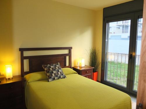 巴约讷Apartamentos Ababides Playa的一间卧室设有一张床和一个大窗户