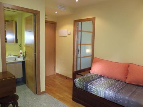 巴约讷Apartamentos Ababides Playa的一间带一张床的卧室和一间带镜子的浴室