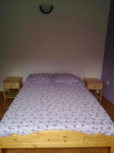 Ribeira GrandeDamontanha的一间卧室配有一张带紫色床单的木床