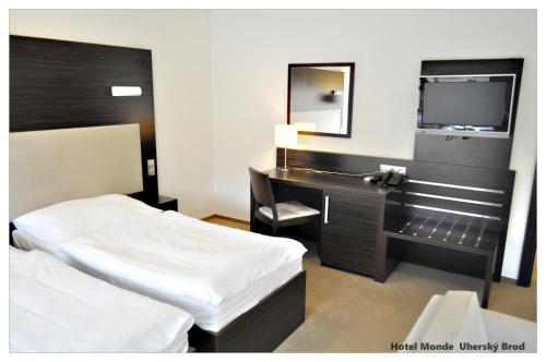 乌赫尔布罗德蒙德酒店的一间卧室配有一张床、一张书桌和一面镜子