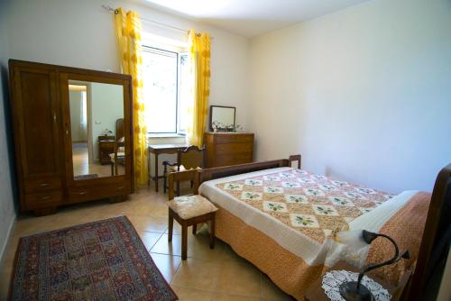 Aiello CalabroB&B CASA VACANZE Benvenuti al Sud的一间卧室配有一张床、梳妆台和镜子