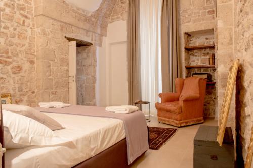 孔韦尔萨诺Dei Balzi Dimore di Charme的一间卧室配有一张床和一张橙色椅子