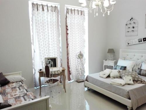 莱切Corte del Pascià的一间卧室配有一张床、一把椅子和一个吊灯。