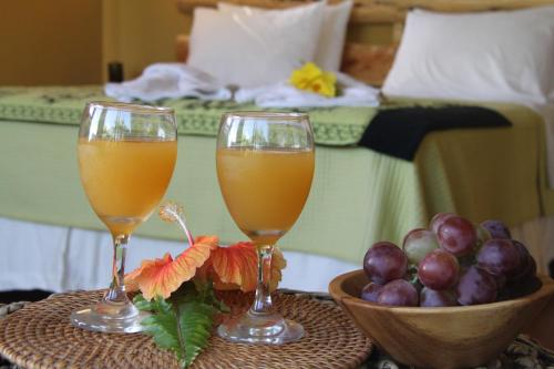 安加罗阿乌卡马纳酒店的在酒店房间桌子上放两杯橙汁和水果