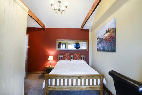 阿特尔伯勒Old Field Barn Luxury B & B的一间卧室设有一张床和红色的墙壁