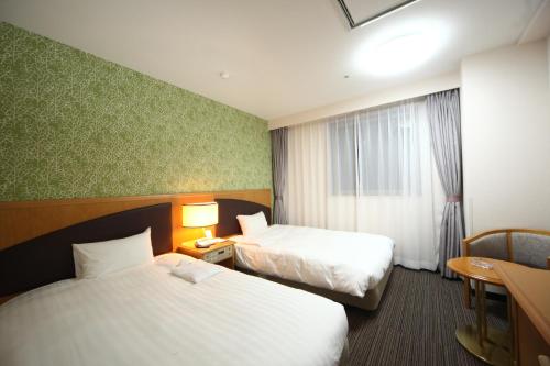 苫小牧市苫小牧永安国际酒店的酒店客房设有两张床和窗户。