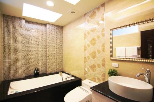 东港22旅店的带浴缸、卫生间和盥洗盆的浴室