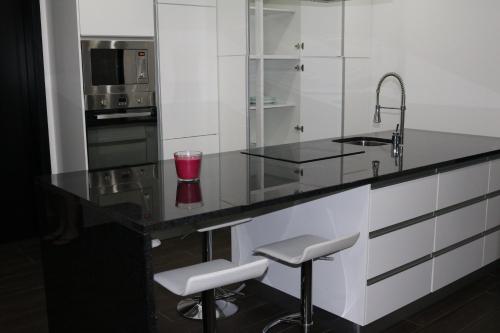 CandeláriaVivenda Paraíso的厨房配有带水槽和凳子的柜台。