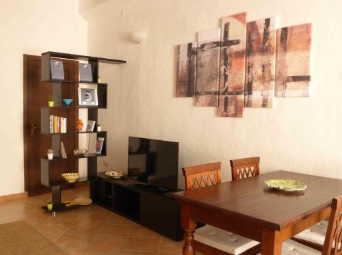 阿尔盖罗老城公寓的一间带桌子和电视的用餐室