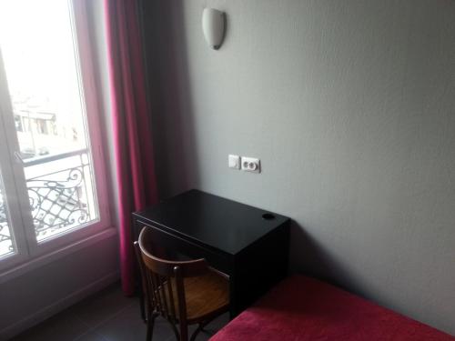 巴黎巴黎巴士底圣安东尼酒店的一张黑桌,靠窗边摆放着椅子