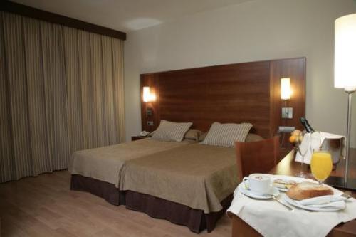 圣达菲BS卡皮图拉西奥斯酒店的酒店客房配有一张床和一张桌子,桌子上装有四面 ⁇ 
