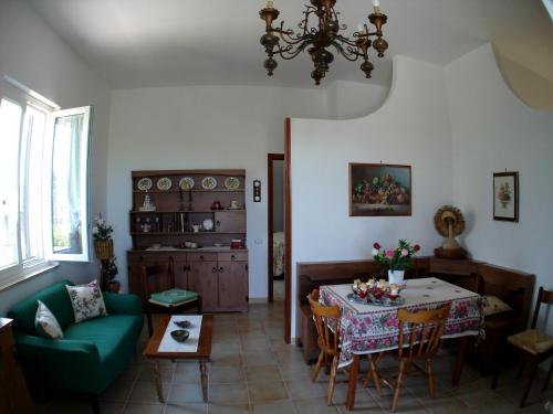 孔韦尔萨诺Villa Maria的客厅配有桌子和绿色沙发