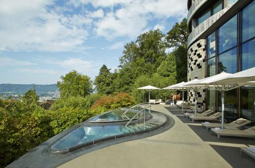 苏黎世The Dolder Grand - City and Spa Resort Zurich的建筑物一侧的游泳池