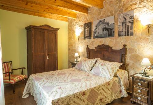 La Mata de los OlmosApartamentos Rurales Millan的一间卧室设有一张床和石墙