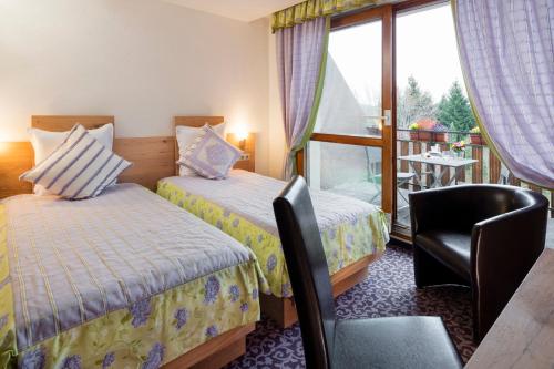 吕塞勒Hotel Restaurant Le Petit Kohlberg的酒店客房设有两张床和一个阳台。
