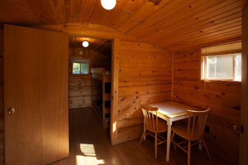Elkhart LakePlymouth Rock Camping Resort One-Bedroom Cabin 6的小木屋配有桌椅