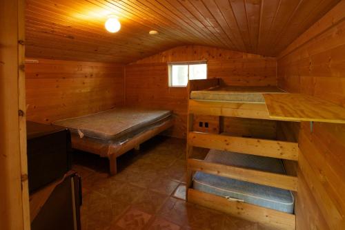 Elkhart LakePlymouth Rock Camping Resort Studio Cabin 2的小屋配有两张双层床。