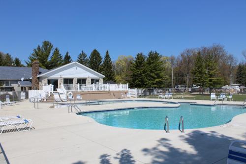 Elkhart LakePlymouth Rock Camping Resort Studio Cabin 2的一个带椅子的大型游泳池