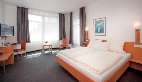 哈雷威斯特法伦霍尔曼酒店的酒店客房设有一张大床和一张书桌。