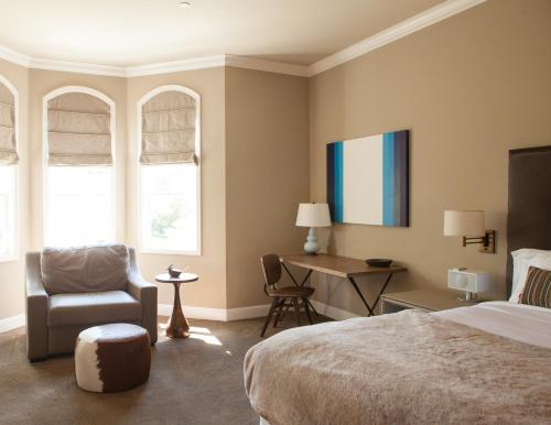 圣海伦娜维德昂酒店的一间卧室配有一张床、一把椅子和一张书桌