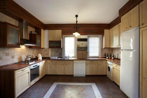 伊斯坦布尔博斯普鲁斯康纳克别墅的厨房配有木制橱柜和白色冰箱。