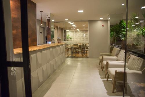 马塞约Amenit Hotel的一个带椅子的大堂和一个带桌子的酒吧