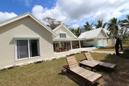 维拉港Vila Del Mare Beachfront Resort的前面有两座木凳的房子