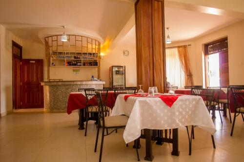 IsioloNorthern Galaxy Hotel的用餐室配有红色和白色桌布的桌子