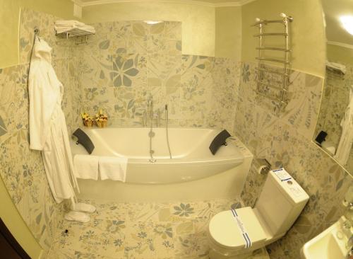 罗夫诺米尔酒店的带浴缸和卫生间的浴室。