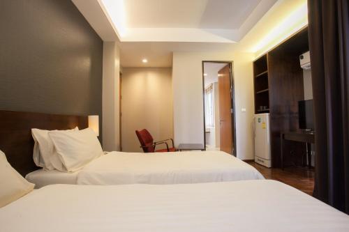 曼谷班西隆第3巷酒店的酒店客房配有两张床和一张书桌